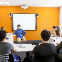 aula llena de alumnos y profesor dando clases