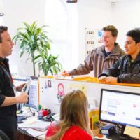 dos chicos informándose en la recepción de la academia